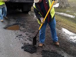 Street worker shoving asphalt